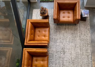 brown leather couch on gray floor